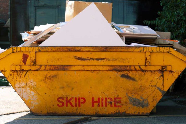 Yellow skip bin with construction and packaging waste - Skip Hire Norfolk