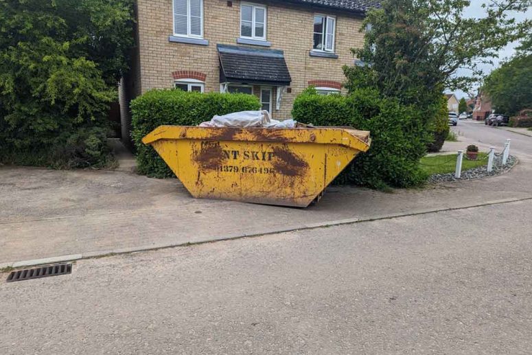 Yellow Kent Skips bin placed on residential driveway - Skip Hire Norfolk